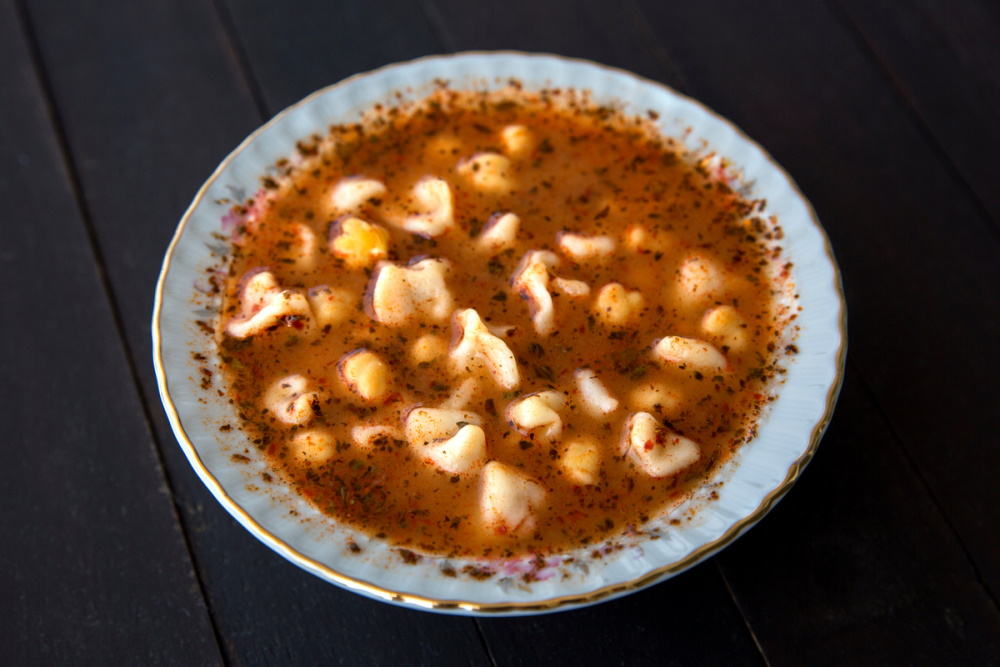 Turkish delicious traditional food Manti soup with tomato sauce